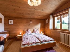 1 dormitorio con 1 cama y pared de madera en Wolkenmooshof en Sankt Johann in Tirol