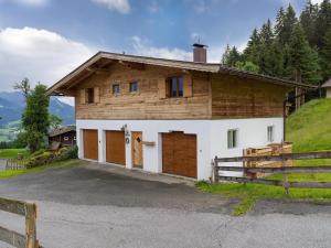 una casa con un granero con una valla en Wolkenmooshof, en Sankt Johann in Tirol