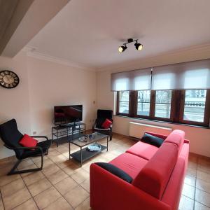sala de estar con sofá rojo y sillas en Le Berceau des Croisades en Bouillon