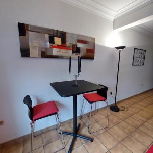 uma mesa com duas cadeiras e um candeeiro num quarto em Le Berceau des Croisades em Bouillon