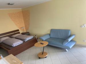 ein Wohnzimmer mit einem Bett und einem blauen Sofa in der Unterkunft Paradies in Bodensdorf