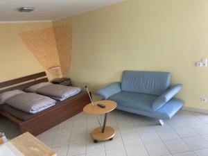 a living room with a bed and a blue couch at Paradies in Bodensdorf