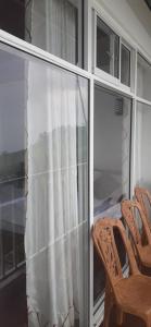 a screened in porch with two chairs and a window at Haputale Super View in Haputale