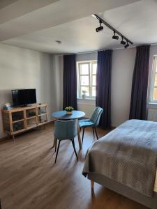 Schlafzimmer mit einem Bett, einem Tisch und einem TV in der Unterkunft Gasthof zur Post in Neunkirchen am Brand