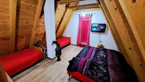 an attic room with two beds and a window at Sarajevo Chalet in Hadžići