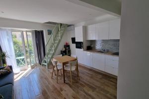 eine Küche und ein Esszimmer mit einem Tisch und einer Treppe in der Unterkunft Appartement Premium in Beaulieu-sur-Mer