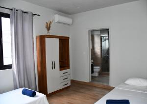 a room with two beds and a bathroom with a toilet at Bel appartement proche de la plage Trou Aux Biches in Trou aux Biches