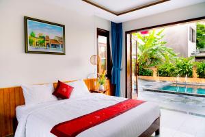 a bedroom with a bed and a swimming pool at Villa Loan A HOI AN in Hoi An