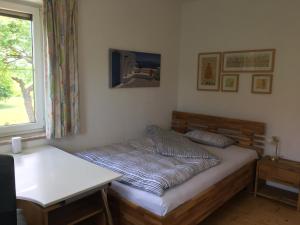 Cama en habitación con mesa y ventana en Gemütliche und geräumige Unterkunft, Nähe Linz, en Luftenberg an der Donau