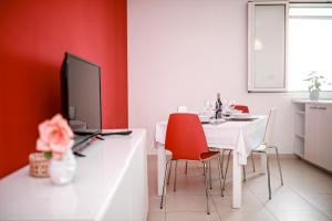 une salle à manger avec une table blanche et des murs rouges dans l'établissement Vieste holiday, à Vieste