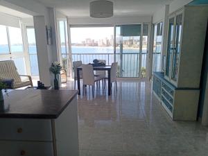 a kitchen and dining room with a view of the water at Apartamento Cabo Azul Playa Campello in El Campello