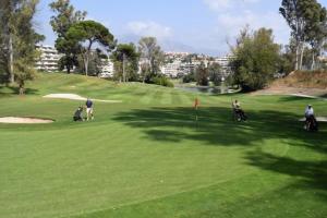 un grupo de personas jugando al golf en un campo de golf en Ático 2 Dormitorios en campo de Golf Guadalmina, Marbella, en Marbella