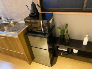 a kitchen with a counter with a microwave and a sink at FTH Moon Light 3min to Sta. in Shimo-yoshida