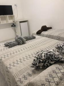Duas camas com almofadas num quarto em Pousada bon vivant praia dos anjos arraial do cabo em Arraial do Cabo