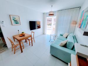 a living room with a blue couch and a table at Gran Ocean View in Playa del Cura