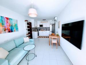 a living room with a blue couch and a table at Gran Ocean View in Playa del Cura