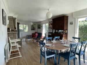 een eetkamer en een woonkamer met een tafel en stoelen bij Vancances relaxantes sur la Presqu ile de Rhuys in Le Tour-du-Parc