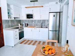 a white kitchen with a plate of fruit on a table at Gran Ocean View in Playa del Cura