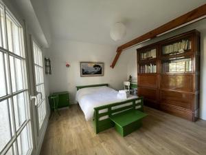 een slaapkamer met een bed met een groene bank erin bij Vancances relaxantes sur la Presqu ile de Rhuys in Le Tour-du-Parc