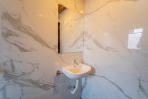 a bathroom with a sink and marble walls at Dhimahi Residency in Mahabaleshwar
