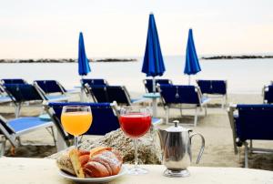 a table with two glasses of wine and bread on the beach at Hotel Crystal in Rimini