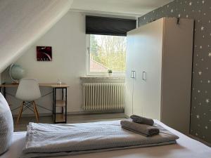 a bedroom with a bed with a cabinet and a desk at Ferienwohnung Am Schwanenteich in Norden