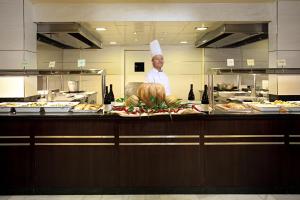 a chef standing behind a counter in a kitchen at Ona Marinas de Nerja Spa Resort in Nerja