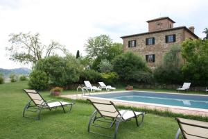a group of chairs sitting next to a swimming pool at Villa Il Poggiarone in Montepulciano