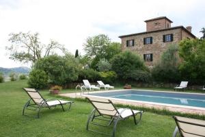 eine Gruppe von Stühlen neben einem Pool in der Unterkunft Villa Il Poggiarone in Montepulciano