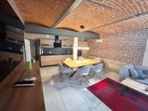 a dining room with a table and a brick wall at Chalet Apartment 1 