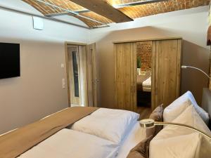 a bedroom with a bed and a couch and a television at Chalet Apartment 1 