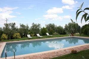 a swimming pool in a yard with two chairs at Villa Il Poggiarone in Montepulciano