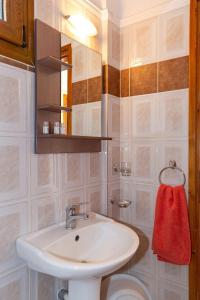 a bathroom with a white sink and a red towel at Pension Veria Frankfurt in Akti Salonikiou