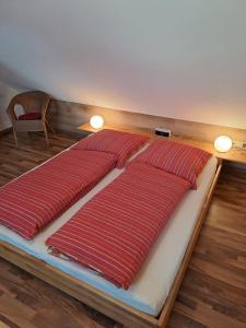 a bed in a room with red pillows on it at Ferienwohnung-Pruemtalblick in Prüm