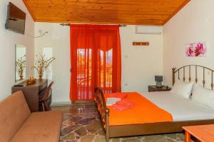 a bedroom with a bed and a couch and a window at Pension Veria Frankfurt in Akti Salonikiou