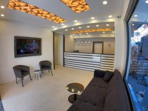 a living room with a couch and chairs and a counter at avsa extra vagant hotel in Avsa Adasi