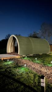 a building with a green and white roof in a field at Orchard Luxe Glamping Pod in Dungannon