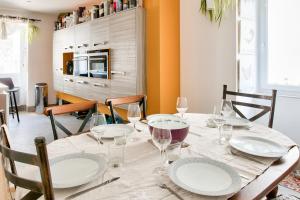 a dining room with a table with plates and wine glasses at Maison classée 4 étoiles pour 6 au coeur du Guilvinec in Le Guilvinec