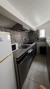eine Küche mit einer Spüle und einem Herd Top-Backofen in der Unterkunft Maison T4 a 6 minutes à pieds de Sarlat in Sarlat-la-Canéda
