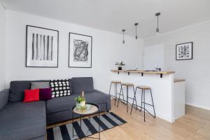a living room with a gray couch and a counter at Pet-Friendly Cosy Studio Skarbińskiego by Renters in Krakow