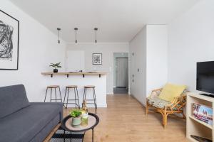 a living room with a couch and a kitchen at Pet-Friendly Cosy Studio Skarbińskiego by Renters in Krakow