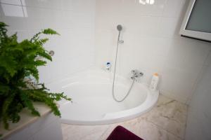 a white bath tub with a shower in a bathroom at Residencial Art Brut in Castellón de la Plana