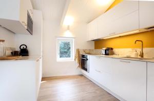 a kitchen with white cabinets and a window at La petite Maison de Gordes 2 nuits minimum in Gordes