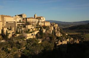 um grupo de edifícios no topo de uma colina em La petite Maison de Gordes 2 nuits minimum em Gordes