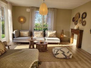 a living room with a couch and a table at Bohemian Wellness met hottub & sauna in Ewijk