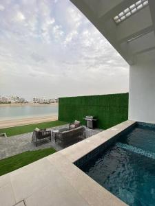 a swimming pool with a table and chairs in a house at Chalet 2200 in Al Khīrān