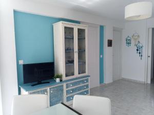 a living room with a tv and a blue wall at Apartamento Cabo Azul Playa Campello in El Campello