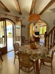 a dining room with a table and chairs at Superb villa with heated private pool - stunning sea and mountain views- Air con in Teulada