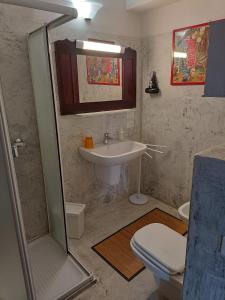 La salle de bains est pourvue d'un lavabo, de toilettes et d'une douche. dans l'établissement B&B La Casarella, à Soiano del Lago