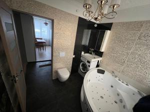 a bathroom with a tub and a toilet and a sink at Lake&Forest&City in Rīga